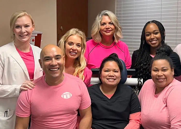 Smiling AQUA employees wear pink to promote breast cancer awareness month.